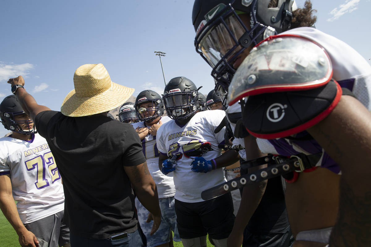 Assistant coach and defensive coordinator Tyrell Tarboro provides guidance to members of the va ...