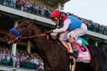 John Velazquez riding Medina Spirit crosses the finish line to win the 147th running of the Ken ...