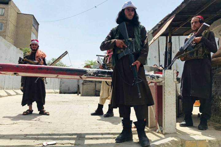 Taliban fighters stand guard at a checkpoint near the US embassy that was previously manned by ...