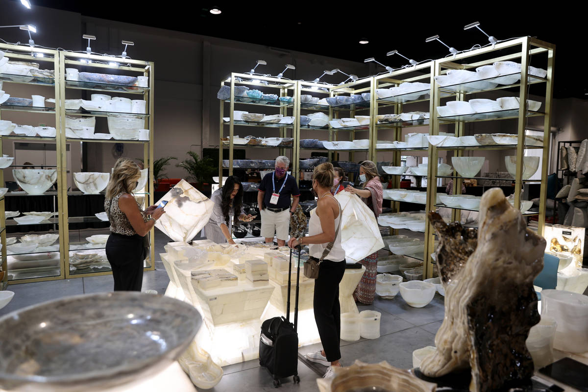 Conventioneers browse the Pierre Verona luxury stone home accents and furniture booth, during t ...