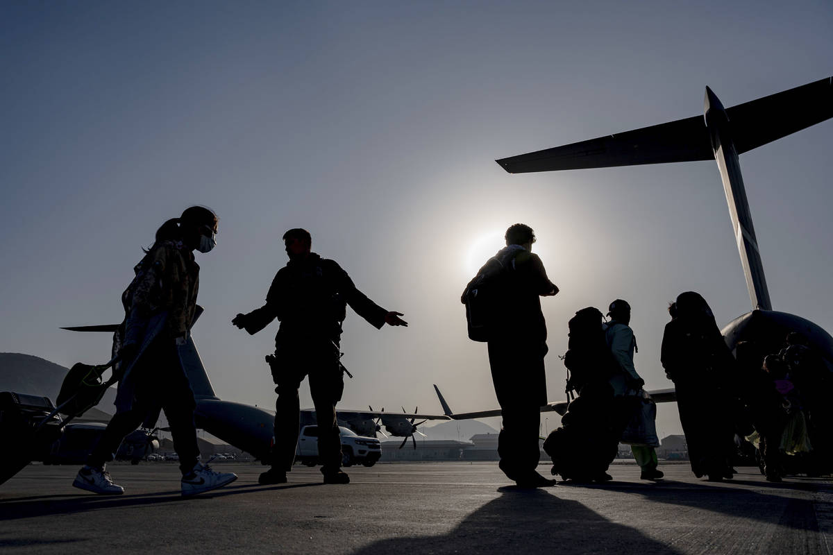 In this image provided by the U.S. Air Force, U.S. Air Force Airmen guides evacuees aboard a U. ...