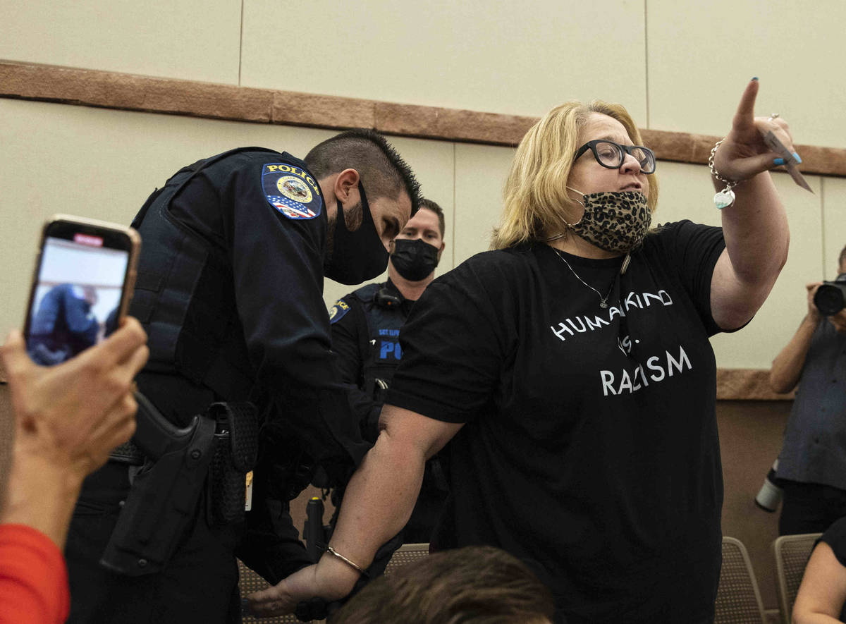 A protester, protesting against a COVID-19 mandate, reacts as she was arrested and escorted out ...