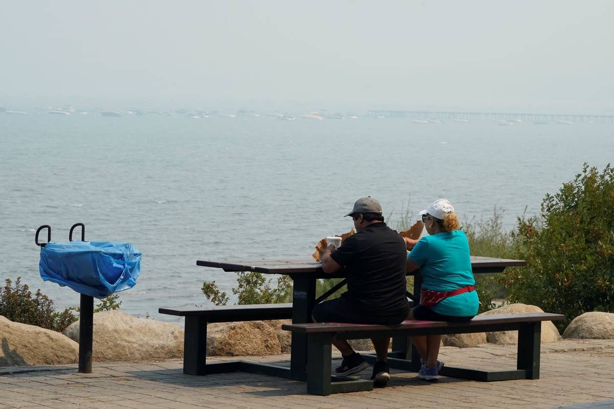 A couple has a meal along the shore of Lake Tahoe in South Lake Tahoe, Calif., Tuesday, Aug. 24 ...