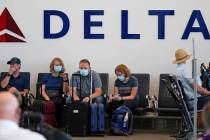 FILE - People sit under Delta sign at Salt Lake City International Airport on July 1, 2021, in ...