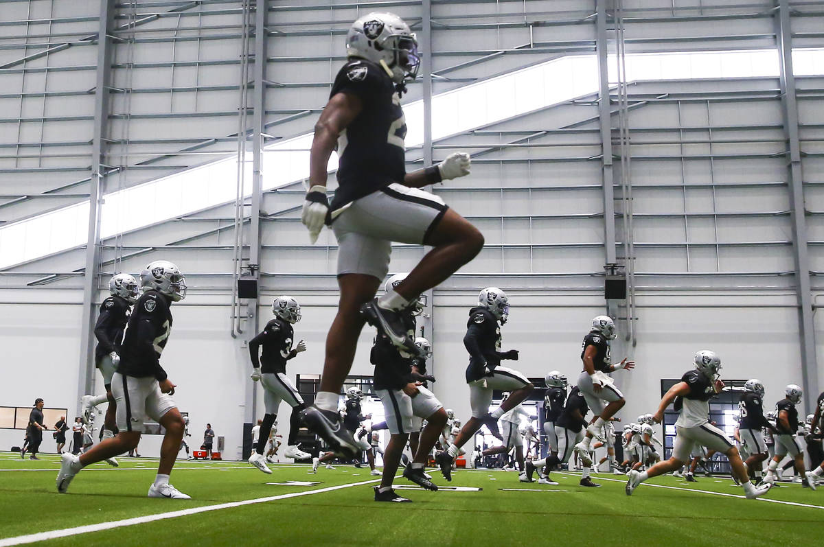 Raiders cornerback Nevin Lawson, above, warms up with teammates during training camp at Raiders ...