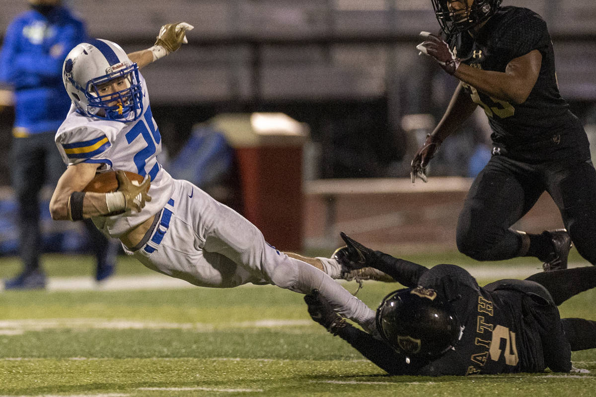 Moapa Valley's Jayme Carvajal (25) is stopped by his feet after a long pass by Faith Lutheran's ...
