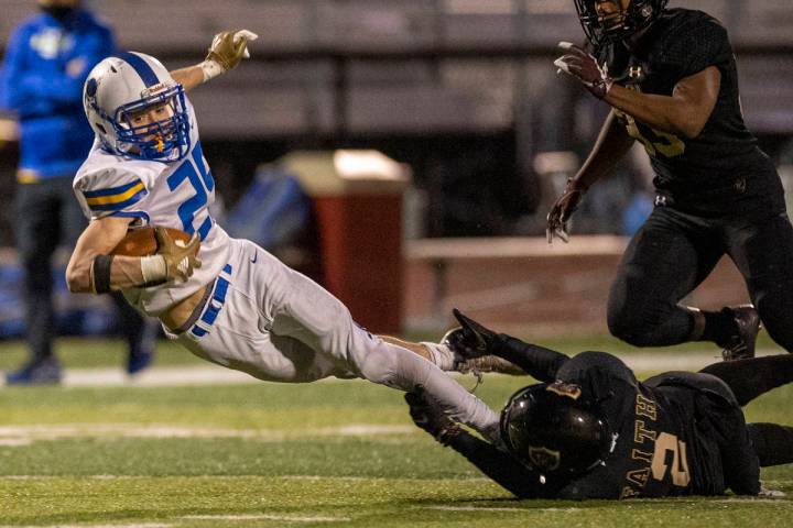 Moapa Valley's Jayme Carvajal (25) is stopped by his feet after a long pass by Faith Lutheran's ...