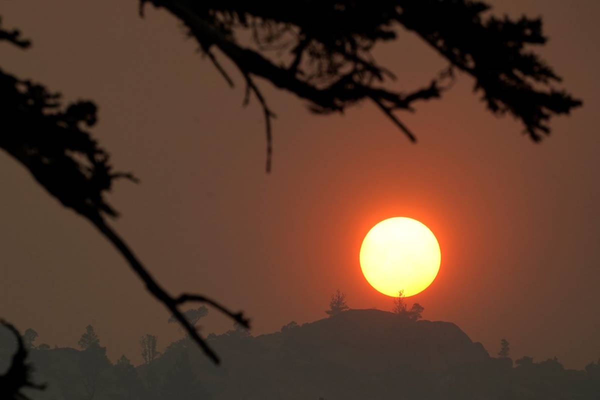 Smoke from the Caldor Fire obscures the sun as it sets over the mountains near South Lake Tahoe ...