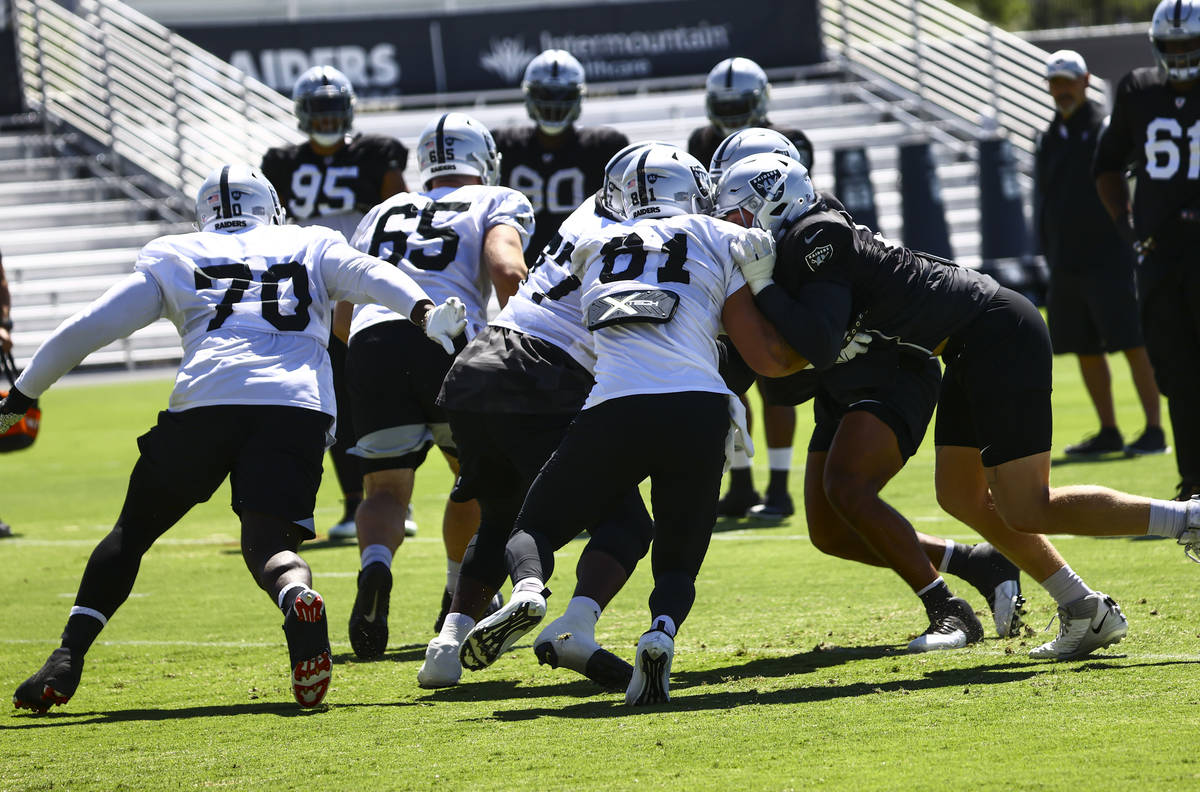Raiders offensive and defensive line players run through drills during training camp at Raiders ...
