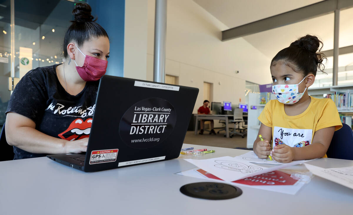 Natisha Gill uses a borrowed laptop with her daughter Jasmine, 5, at the East Las Vegas Library ...