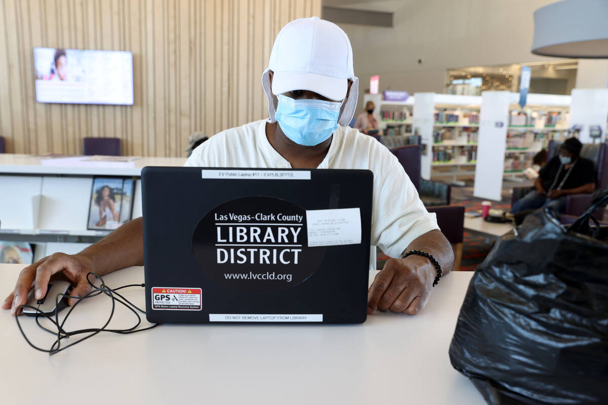 James Kelley uses a borrowed laptop at the East Las Vegas Library Monday, Aug. 9, 2021. (K.M. C ...