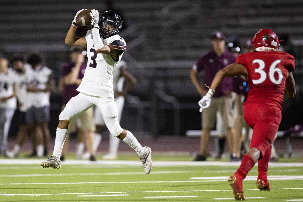 Faith Lutheran's Nicholas Crowell (3) makes a catch as Arbor View's Marcus Young rushes to make ...
