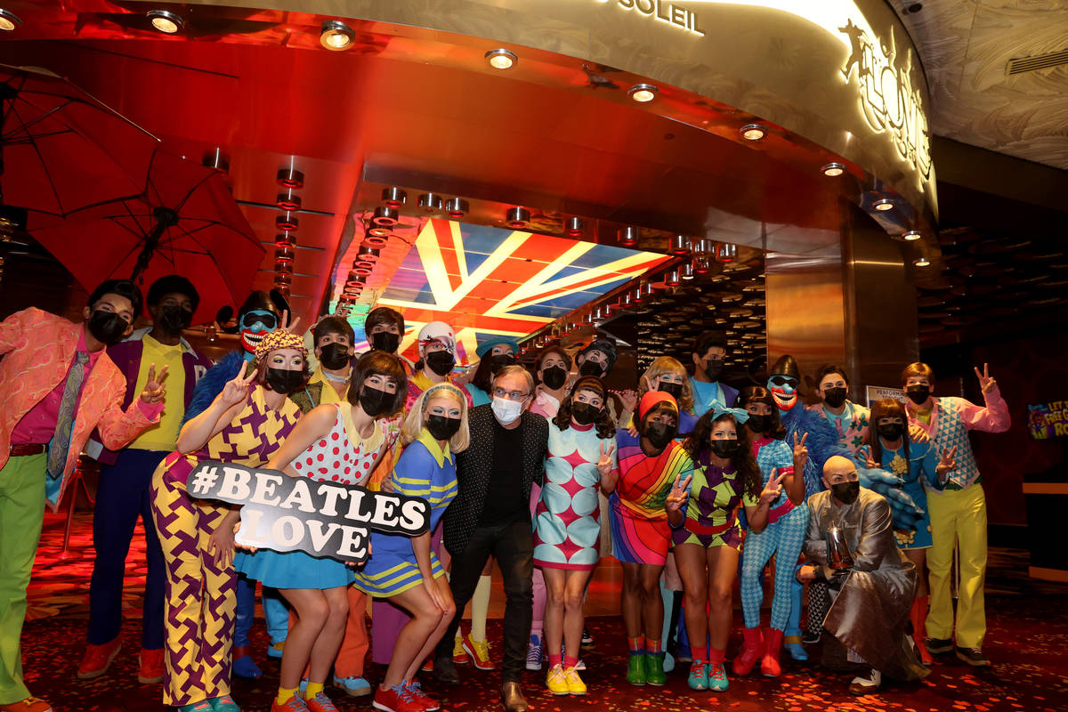 The cast of The Beatles LOVE, including Daniel Lamarre, president and CEO, center, entertain gu ...