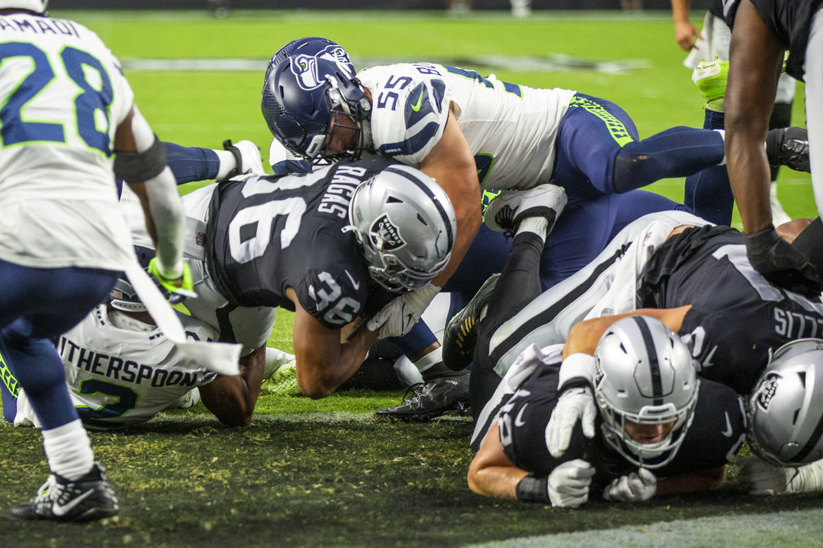 Raiders running back Trey Ragas (36) scores the first touchdown as Seattle Seahawks linebacker ...