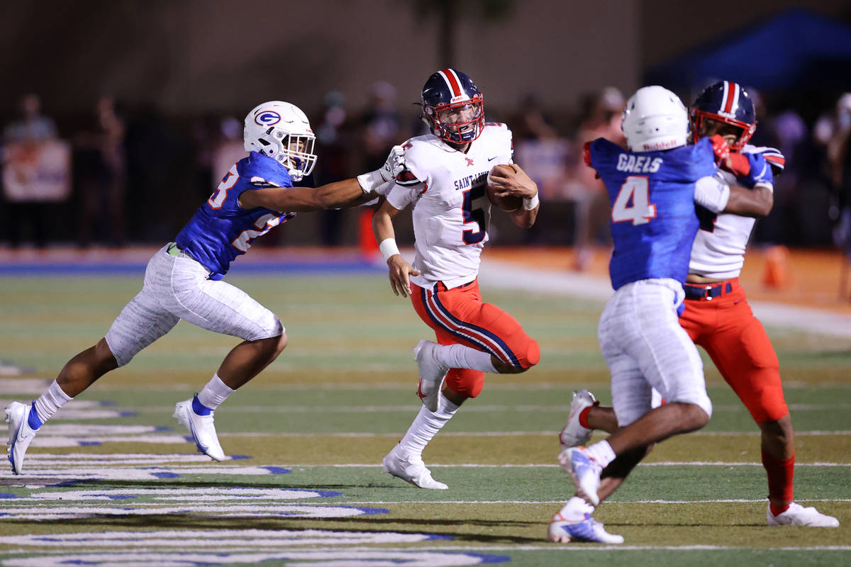 St. Louis Kaiwi Batoon (5) runs the ball under pressure from Bishop Gorman's Quincy Davis (23) ...