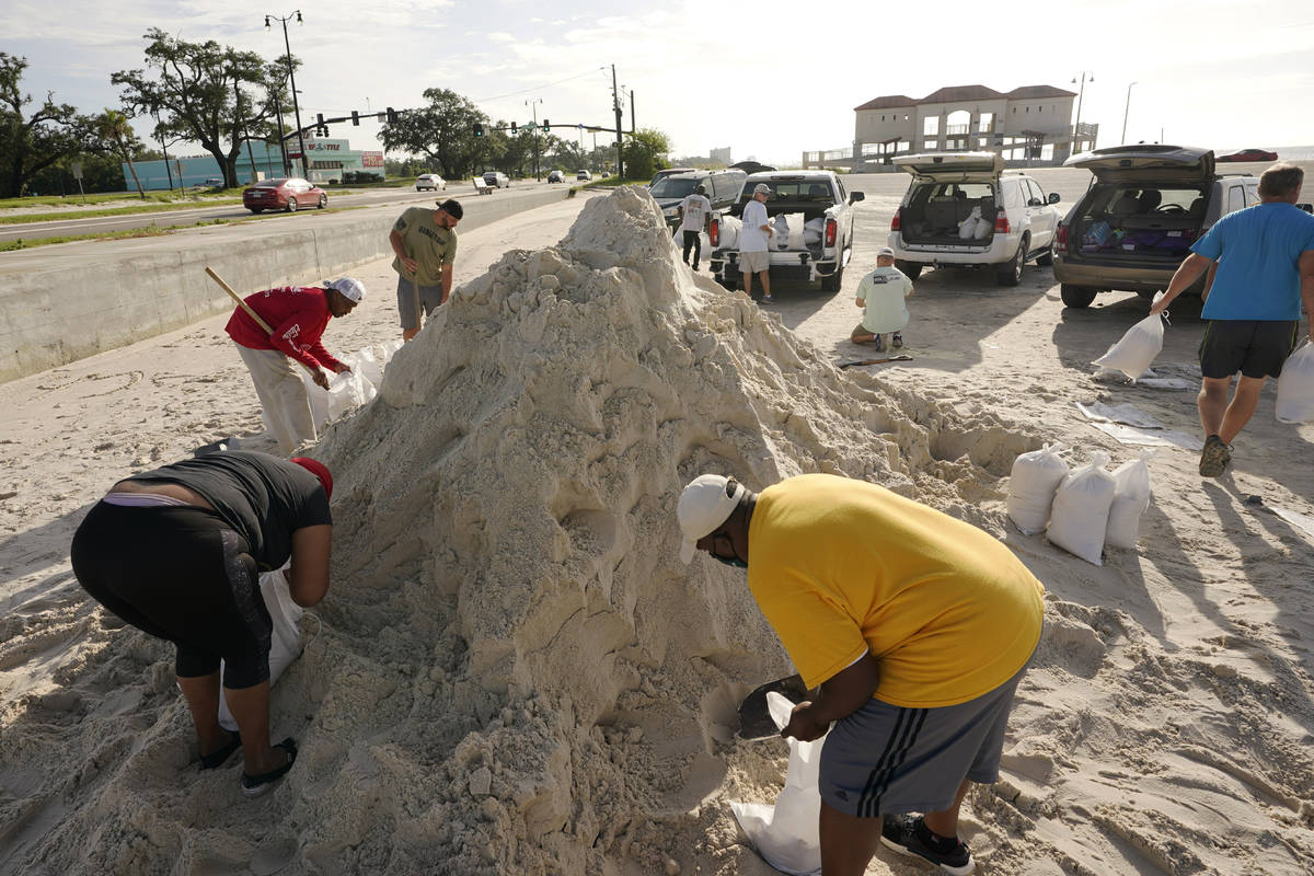 Local residents fill sand bags as they prepare for the expected arrival of Hurricane Ida Saturd ...