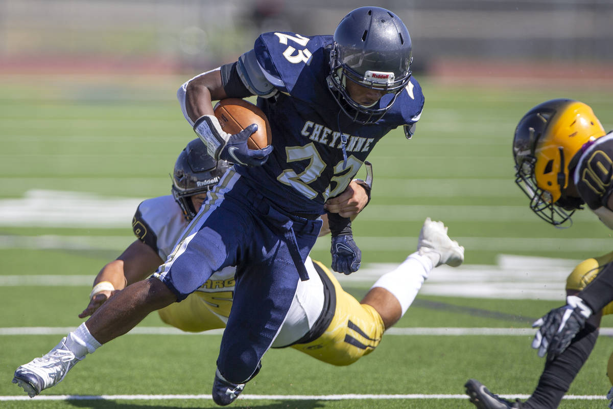 Cheyenne running back Anthony Egnor (23) is tackled by Clark linebacker Reyes Reynaga (59) duri ...