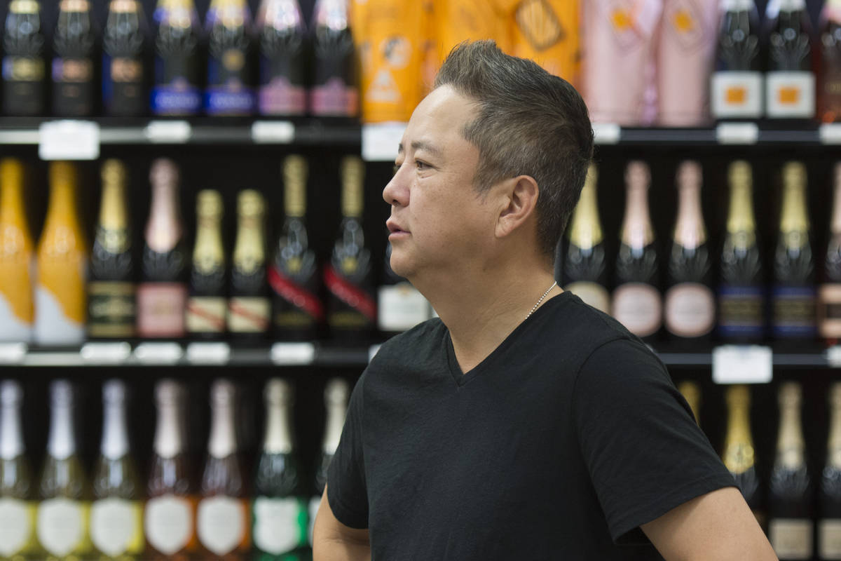Kenny Lee, president of Lee's Discount Liquor, watches shoppers during the grand opening of the ...