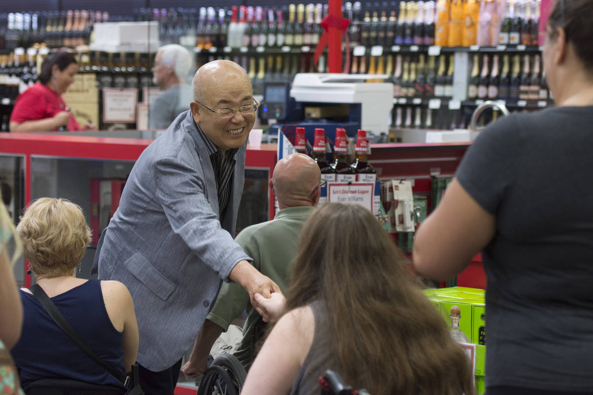 Hae Un Lee, founder of Lee's Discount Liquor, greets shoppers during the grand opening of the s ...