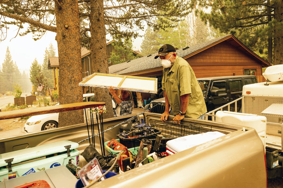 Bob Hansen and Patty Kingsbury evacuate from their South Lake Tahoe, Calif. home as the Caldor ...
