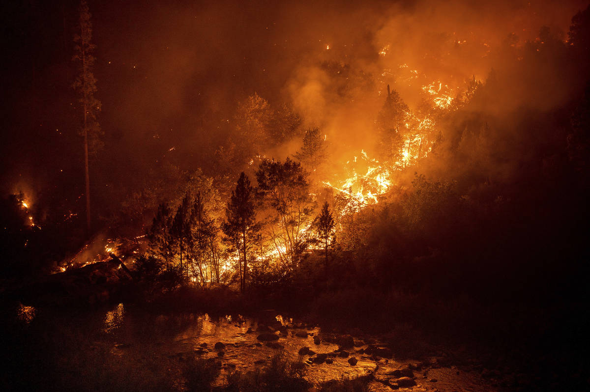 The Caldor Fire burns above the South Fork of the American River in the White Hall community of ...