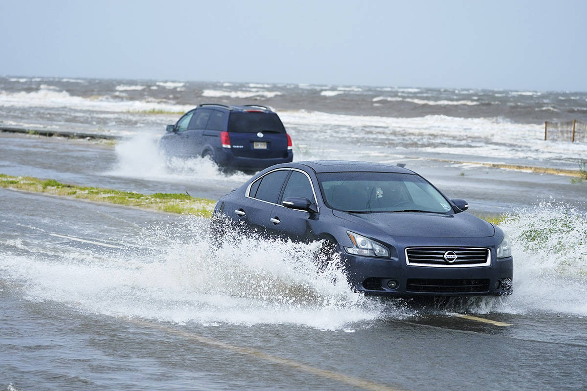 Cars drive through flood waters along route 90 as outer bands of Hurricane Ida arrive Sunday, A ...