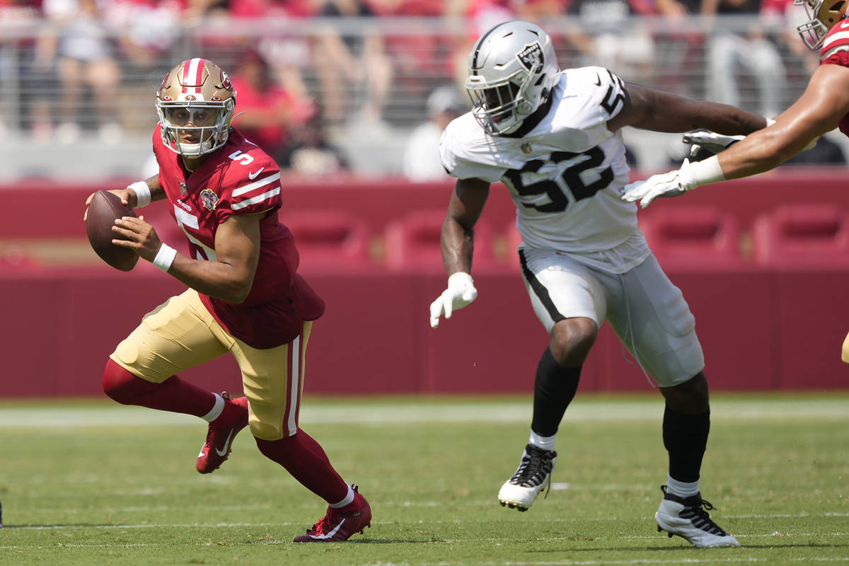 San Francisco 49ers quarterback Trey Lance (5) scrambles from Las Vegas Raiders defensive end G ...