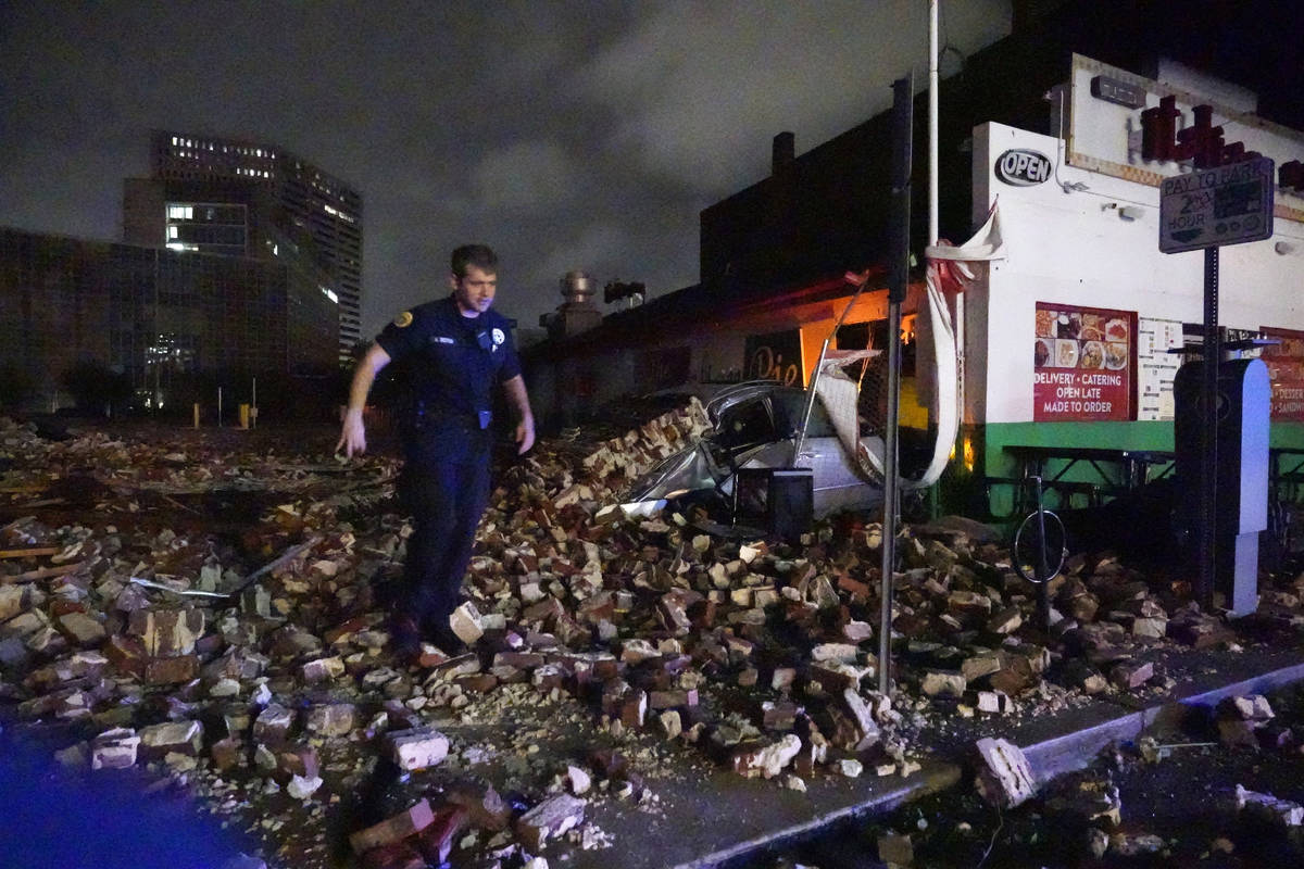 New Orleans Police detective Alexander Reiter, looks over debris from a building that collapsed ...