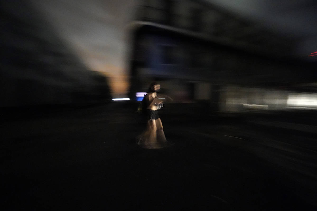 A woman walks down Bourbon Street in the French Quarter in the aftermath of Hurricane Ida in Ne ...