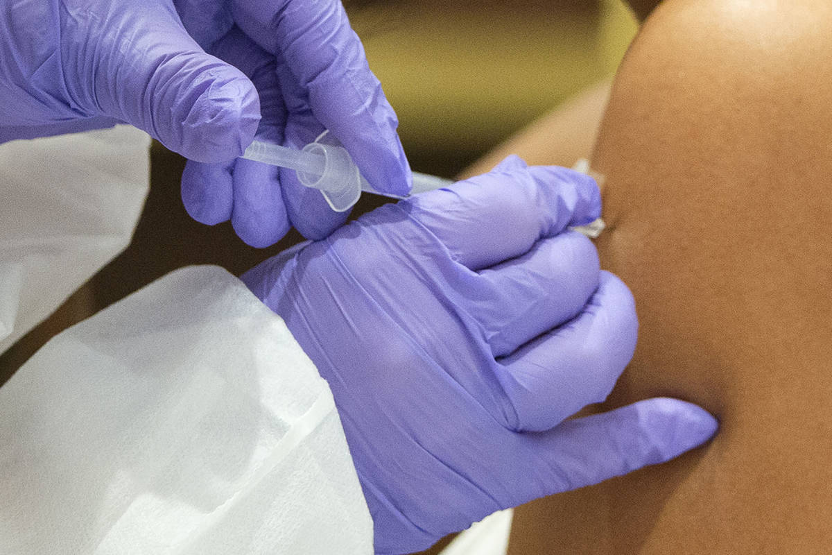 A woman receives a COVID-19 vaccination shot during a vaccine clinic hosted by Immunize Nevada ...