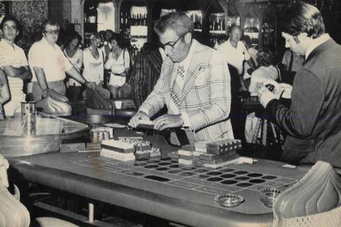 Agents count chips at a roulette wheel while Aladdin Hotel casino employees watch after state g ...
