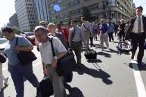 Workers leave buildings in the area near the White House in Washington Tuesday morning, Sept. 1 ...