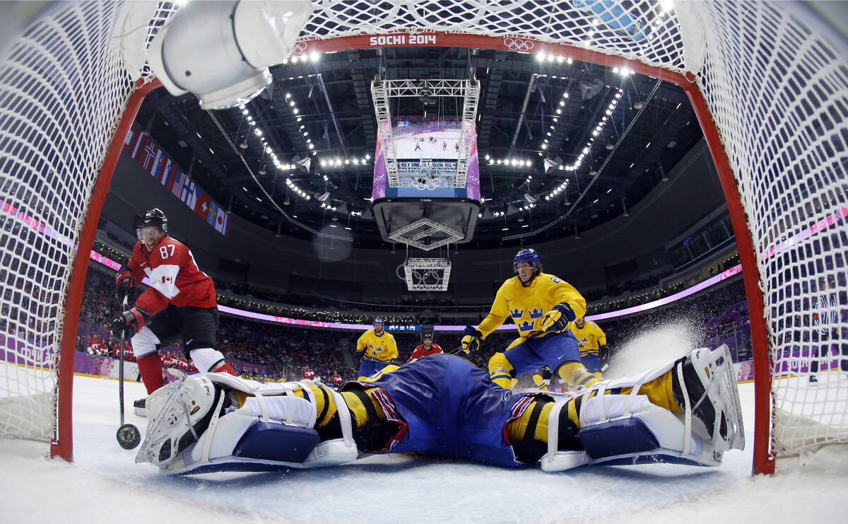 In this Feb. 23, 2014, file photo, Canada forward Sidney Crosby, left, scores a goal past Swede ...
