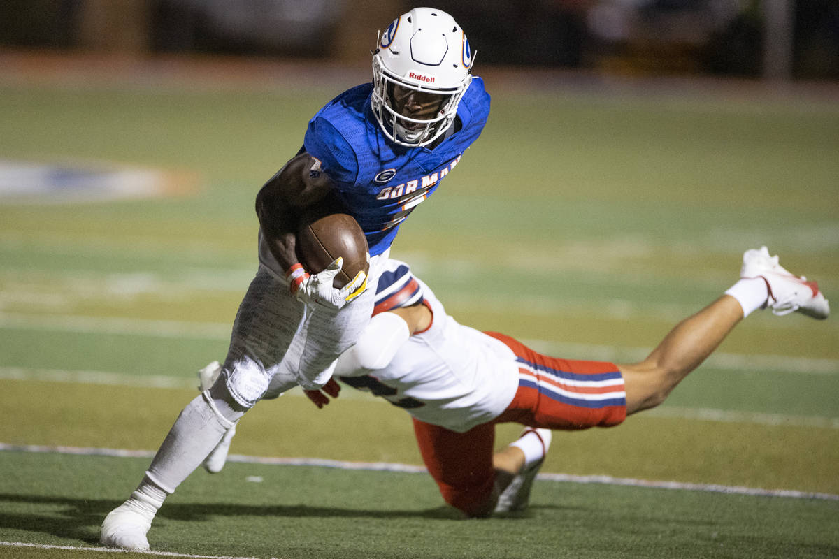 Bishop Gorman's Zachariah Branch (1) breaks a tackle from St. Louis Kona Moore (2) during the t ...