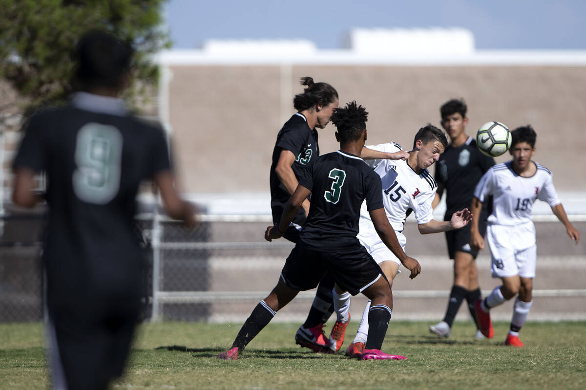 Liberty's Anthony Angotti (15) heads the ball surrounded by Palo Verde's Quentin Gomez (13) and ...
