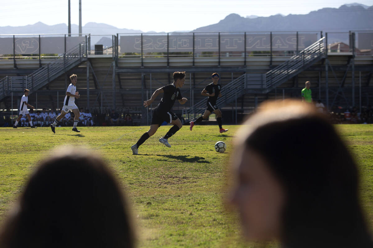 Palo Verde's Elad Cohen (8) makes way down the field while fans chat in the foreground during a ...