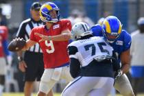 Los Angeles Rams quarterback Matthew Stafford looks for a receiver while Dallas Cowboys defensi ...