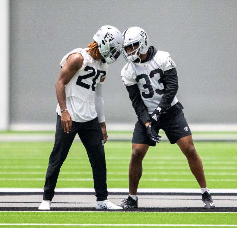 Raiders cornerback Damon Arnette (20) and safety Roderic Teamer (33) have a close conversation ...