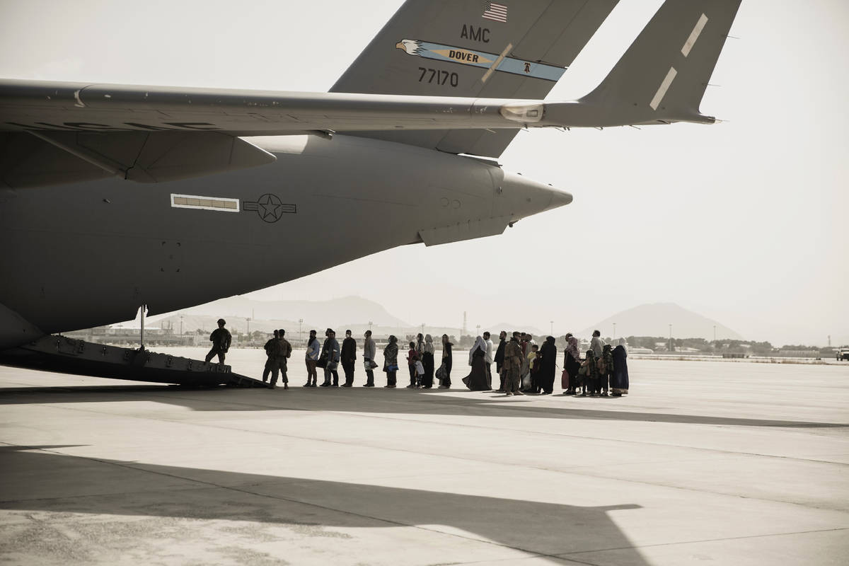 In this image provided by the U.S. Marine Corps, evacuees wait to board a Boeing C-17 Globemast ...
