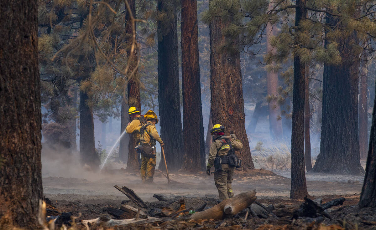 Firefighters mop up spot fires along SR 89 from the Caldor Fire on Wednesday, Sept. 1, 2021, in ...