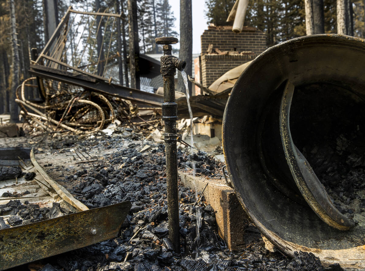 Water runs from a faucet at a home destroyed by the Caldor Fire in the Phillips Park neighborho ...