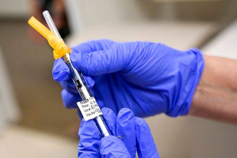 A nurse prepares to administers a Pfizer COVID-19 booster shot on Thursday, Aug. 19, 2021, at U ...