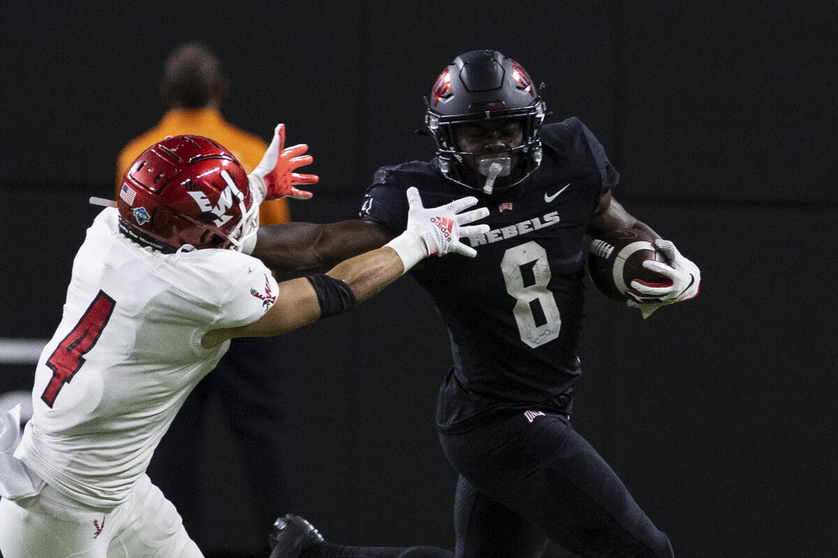 UNLV Rebels running back Charles Williams (8) fends off a tackle attempt by Eastern Washington ...