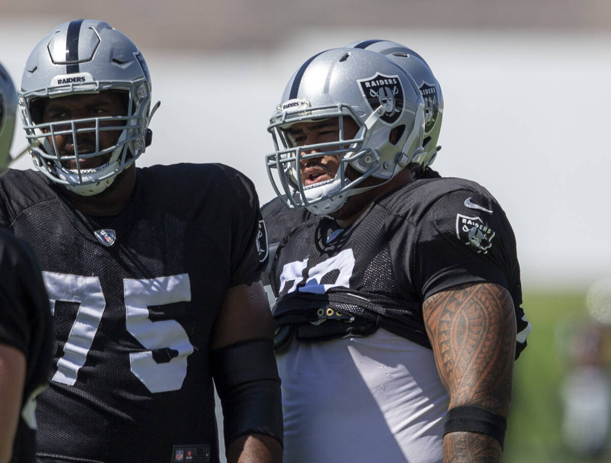 Raiders offensive lineman Jeremiah Poutasi (79) looks on with offensive tackle Brandon Parker ( ...