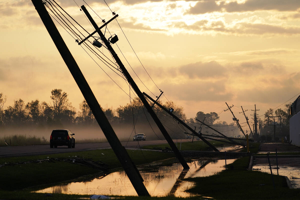 Downed power lines slump over a road in the aftermath of Hurricane Ida, Friday, Sept. 3, 2021, ...