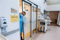 A nurse sticks her head out of a room of a COVID-19 patient in the CoxHealth Emergency Departme ...