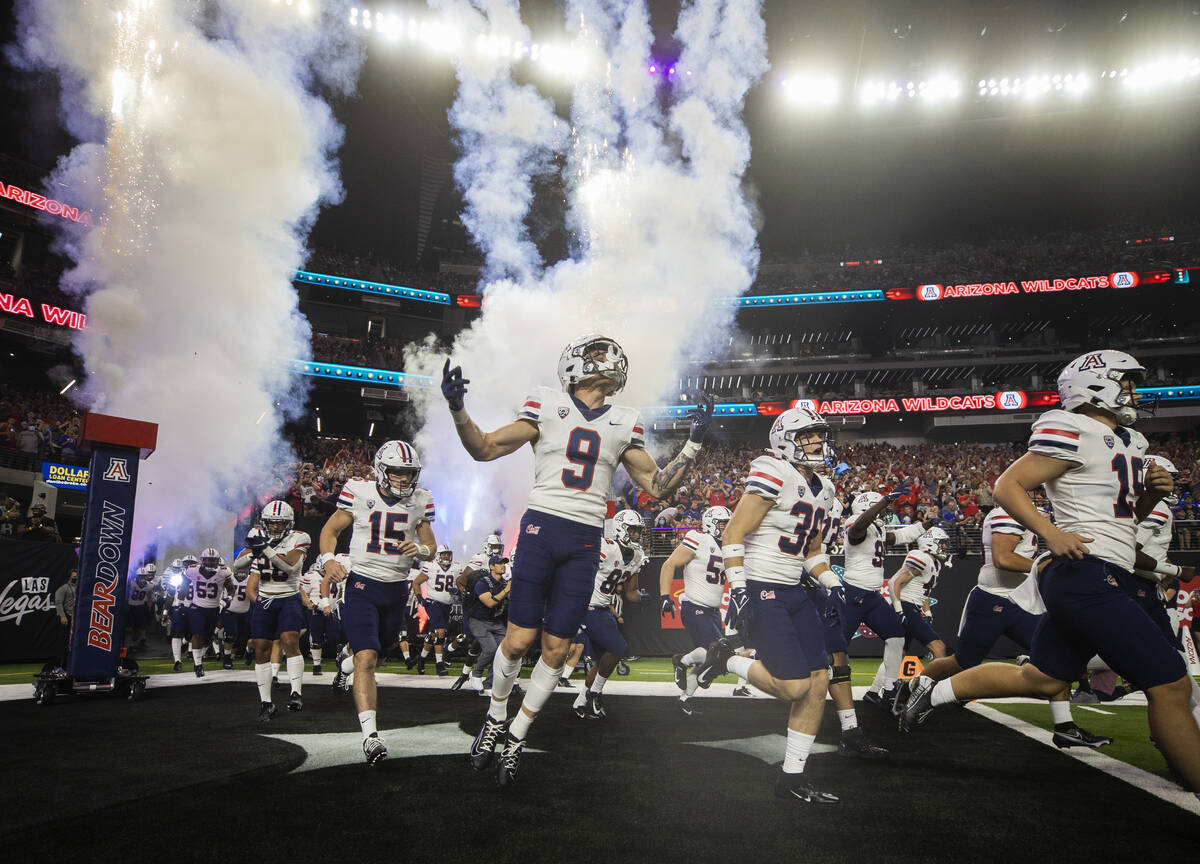 Arizona Wildcat players take the field before the start of a college football game against the ...