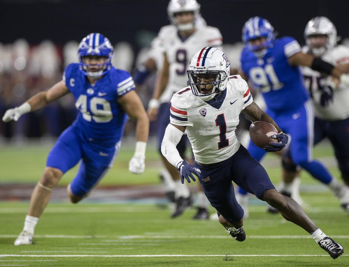 Arizona Wildcat wide receiver Stanley Berryhill III breaks a big run past Brigham Young Cougars ...