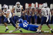 Arizona Wildcats quarterback Gunner Cruz scrambles past Brigham Young Cougars linebacker Keenan ...