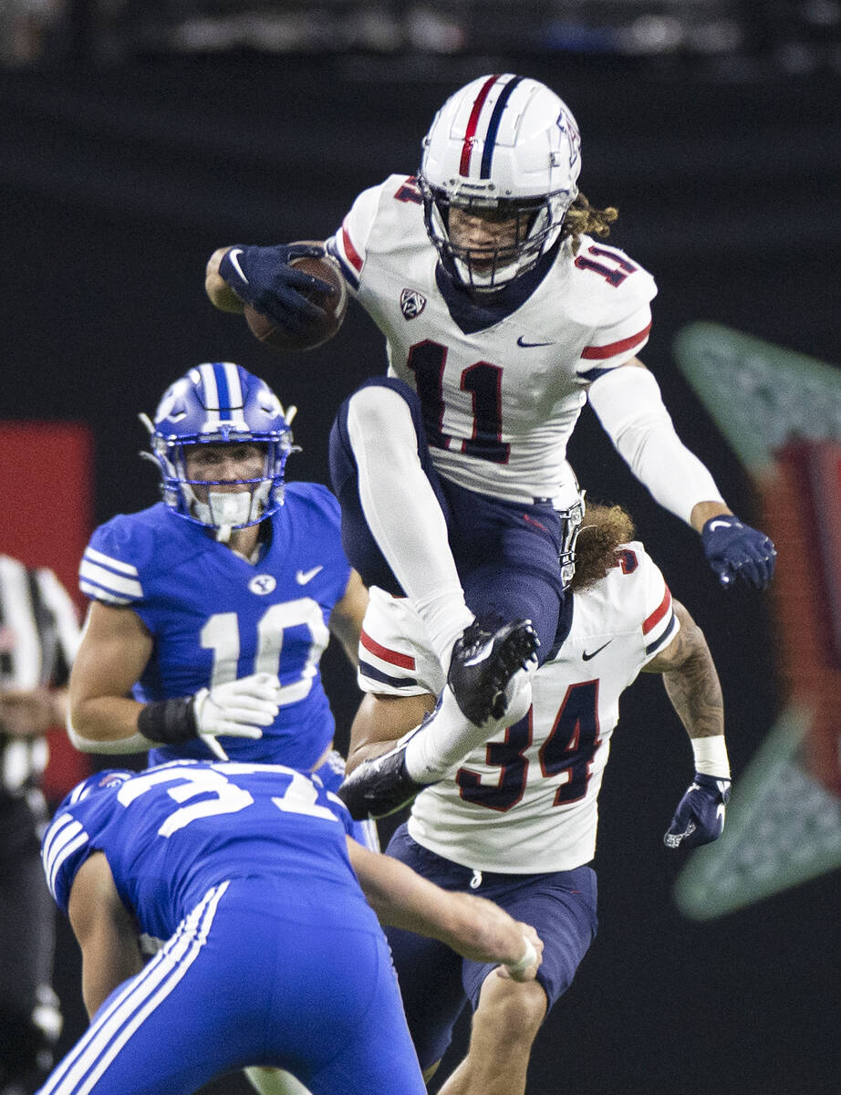 Arizona Wildcats wide receiver Tayvian Cunningham (11) leaps over Brigham Young Cougars linebac ...